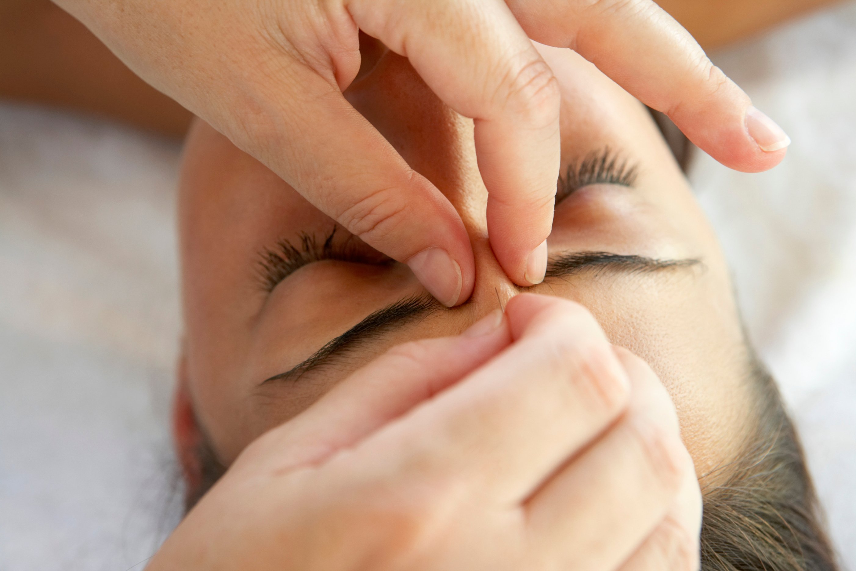 Therapist massaging woman's nose